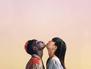 Couples looking up with colorful sunscreen on their nose.